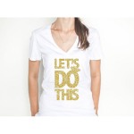 Let's Do This Gold Glitter V-Neck Shirt ~The "Let's Do This." graphic sparkles in glitter gold against the white v-neck tee. The ring motif is a fun addition and let's everyone know a wedding is happening! This is a beautiful bride's t-shirt that let's everyone know who the bride or newlywed while celebrating!